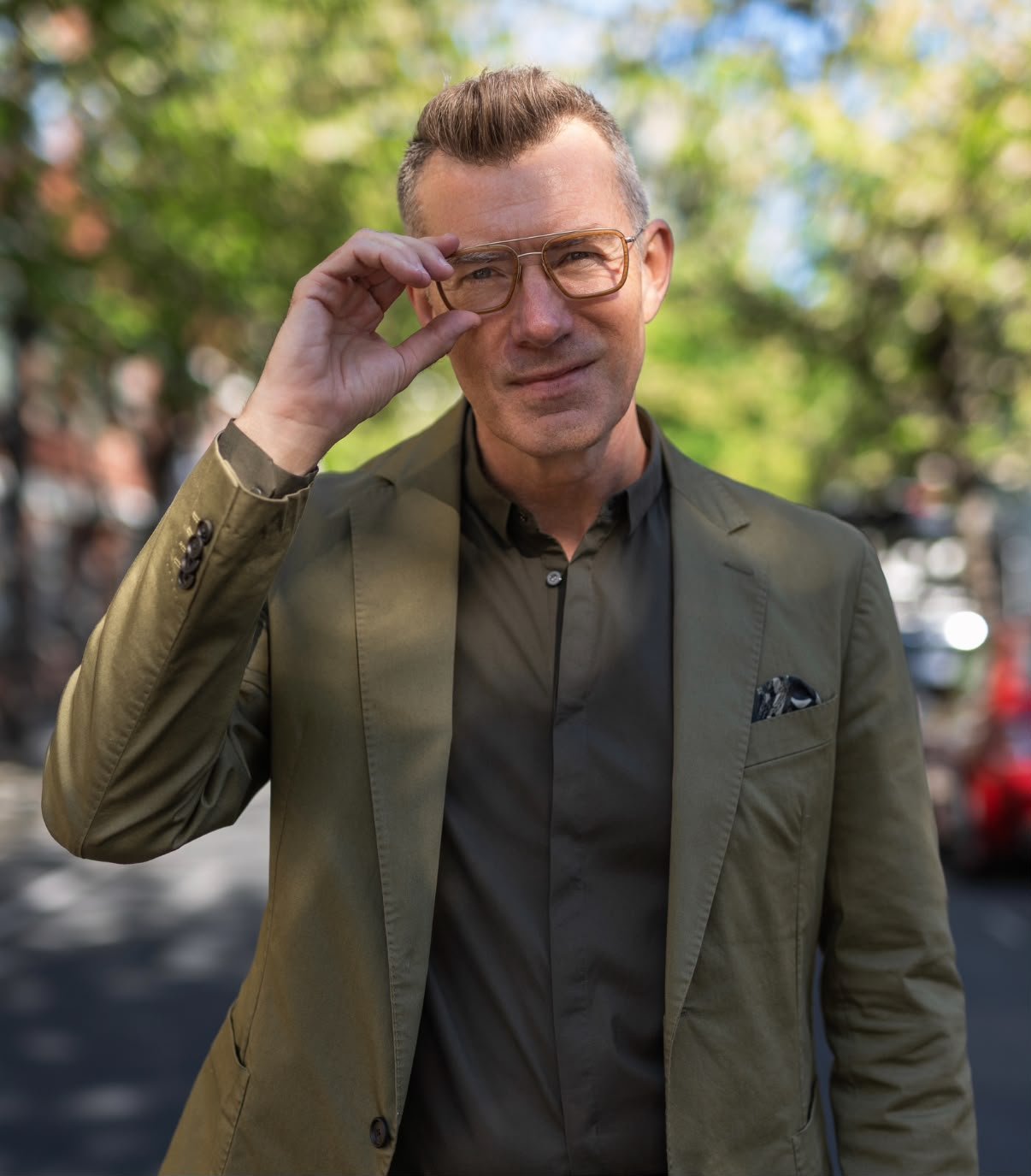 Phill Tarling, London menswear stylist, in an olive cotton jacket on a tree-lined London street