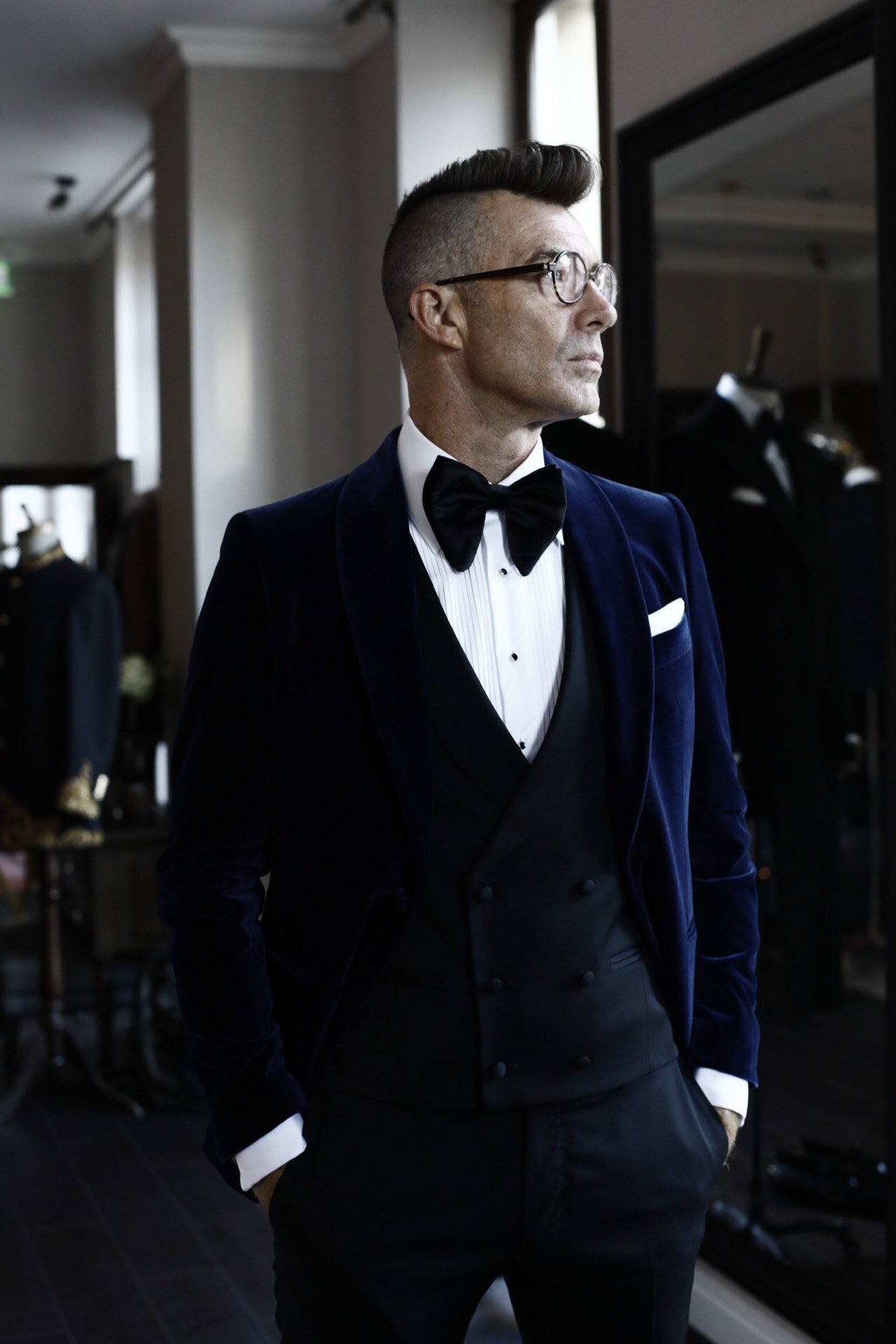 Phill Tarling in a navy velvet dinner jacket and black bow tie in a London tailoring room